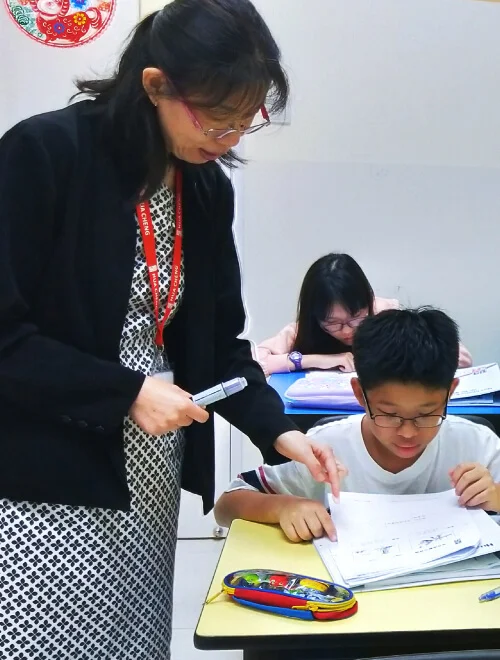 Hua Cheng Education Centre classroom with students learning Chinese through MOE-aligned lessons focused on vocabulary and comprehension.