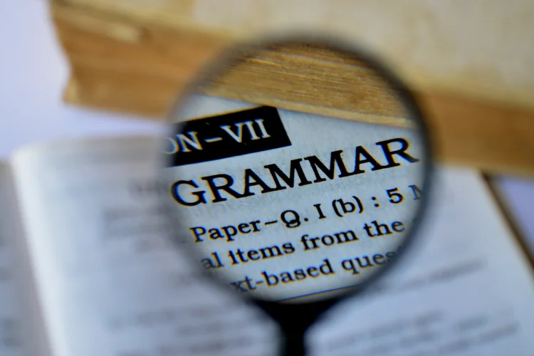 Magnified grammar section of an English paper showing sentence structure and transformation tips.