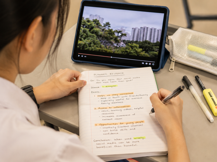 Student preparing notes for an O Level English Oral response.